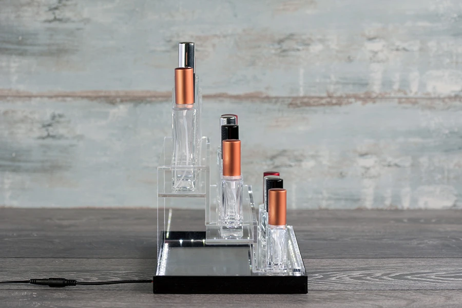 Stalak od plexiglassa osvetljen sa LED trakom za flašice za parfeme i flašice raznih oblika, osnova je bela ili crna – za 12 bočica-grupa_slika